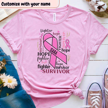 Pink t-shirt with breast cancer awareness design on a wooden surface with flowers and jeans.